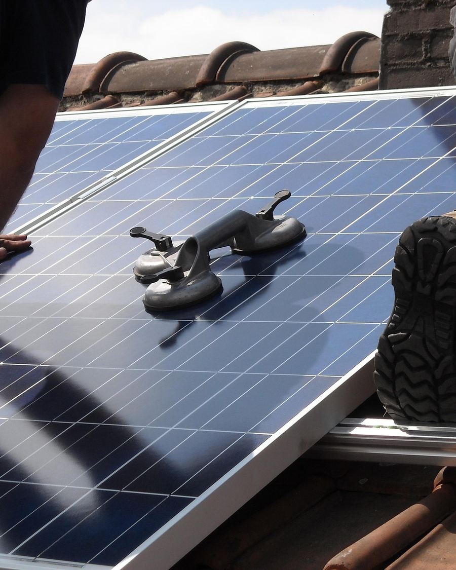 Two Janarix installers lowering a panel onto its mounting rail